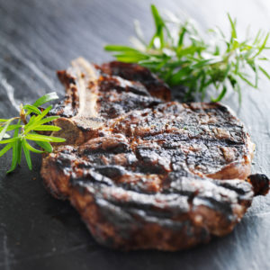 grilled prime rib beef steak with rosemary on slate